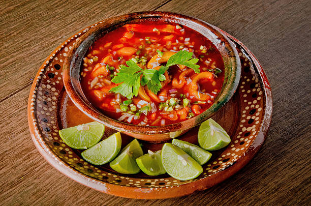 traditional mexican menudo soup (pancita de res) with fresh lime wedges